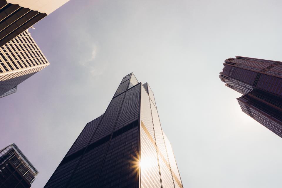 Looking up at modern towers against a bright sky