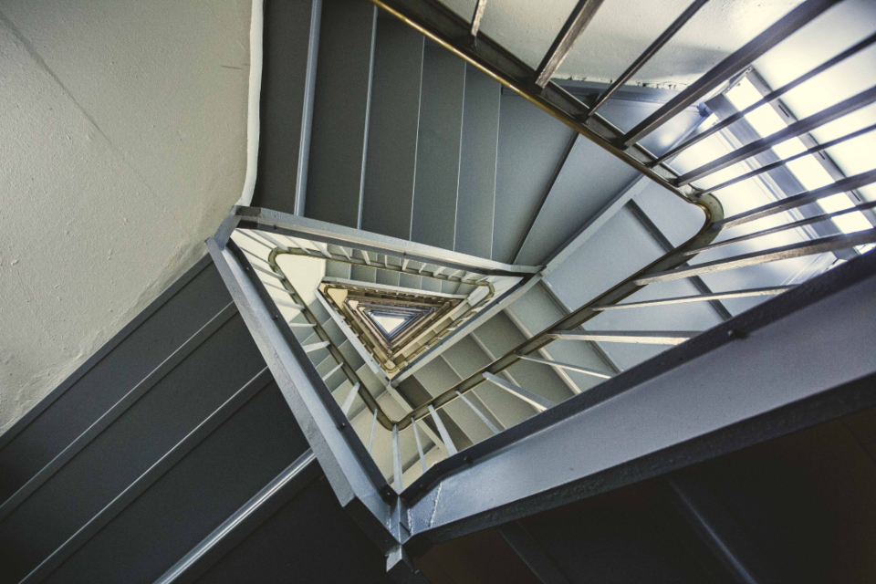 A geometric stairwell ascending towards the light